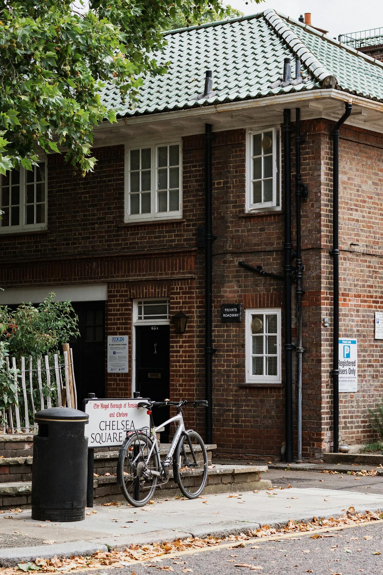Casa de tijolos em estilo britânico com bicicleta na calçada em rua residencial de Londres