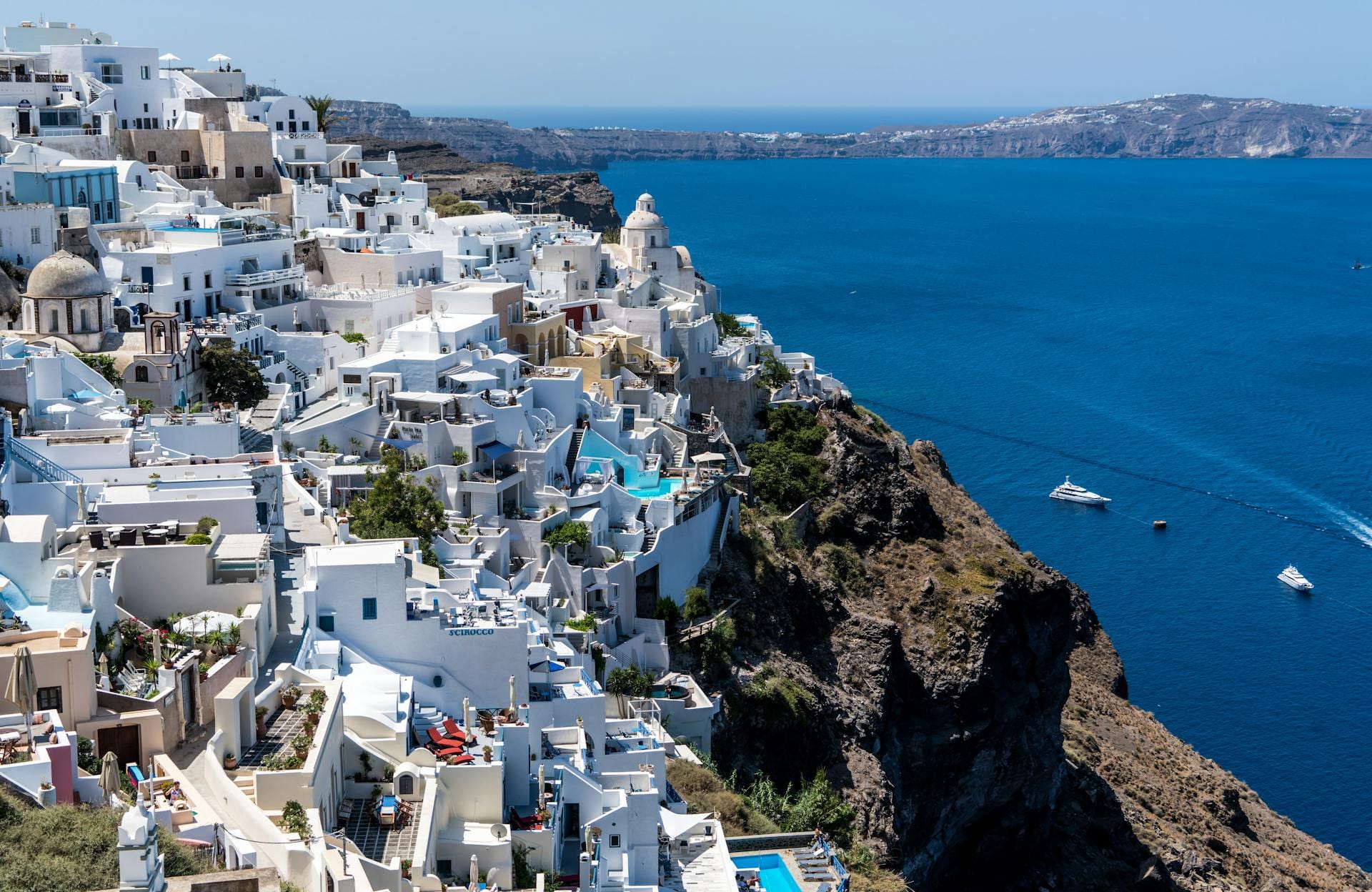 Casas brancas em Santorini, Grécia, com vista para o mar Egeu e falésias