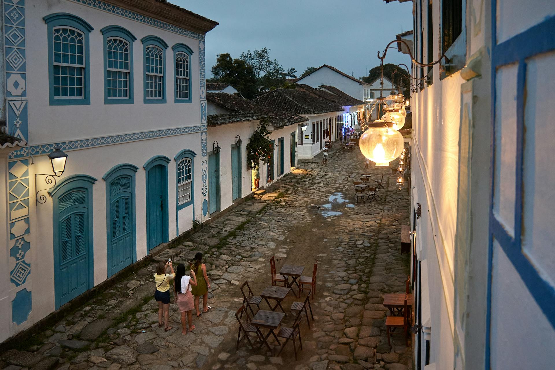 Centro histórico de Paraty, com rua de pedra e casas coloniais iluminadas ao entardecer