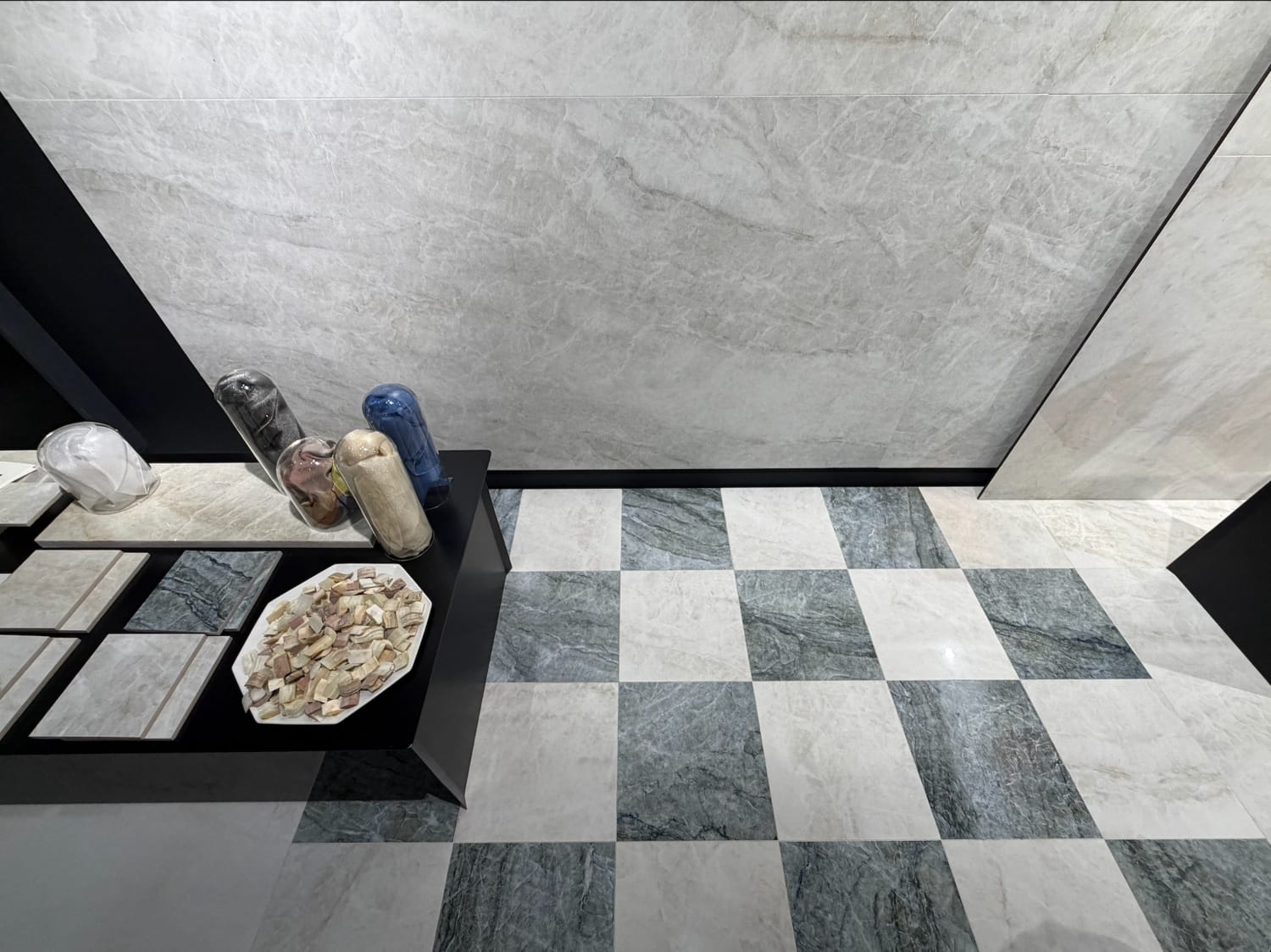 Ambiente com revestimentos, incluindo piso quadriculado e parede em mármore claro.