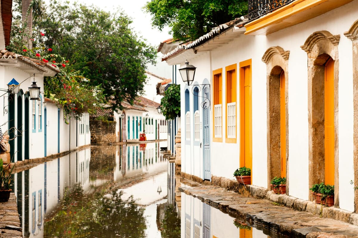 Rua de Paraty, com casas coloniais coloridas refletidas no chão molhado
